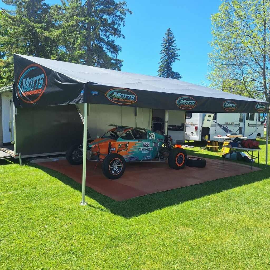 Motts Motorsports race trailer awning with a race car parked underneath