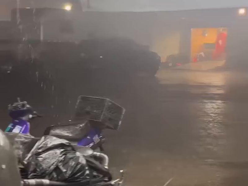 Rain pouring past the BTnT Racing funny car chassis, dry under the team's DMP awning at Funny Car Chaos in Albuquerque
