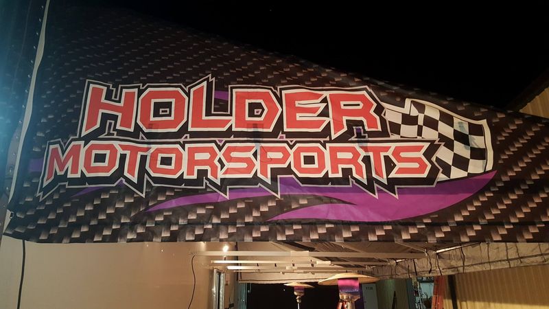 Holder Motorsports awning end cap printed in-house with a carbon fiber background and checkered flag