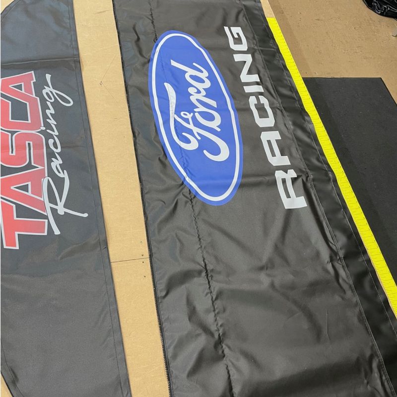 Tasca Racing and Ford Racing graphics freshly printed on awning fabric in the DMP print shop