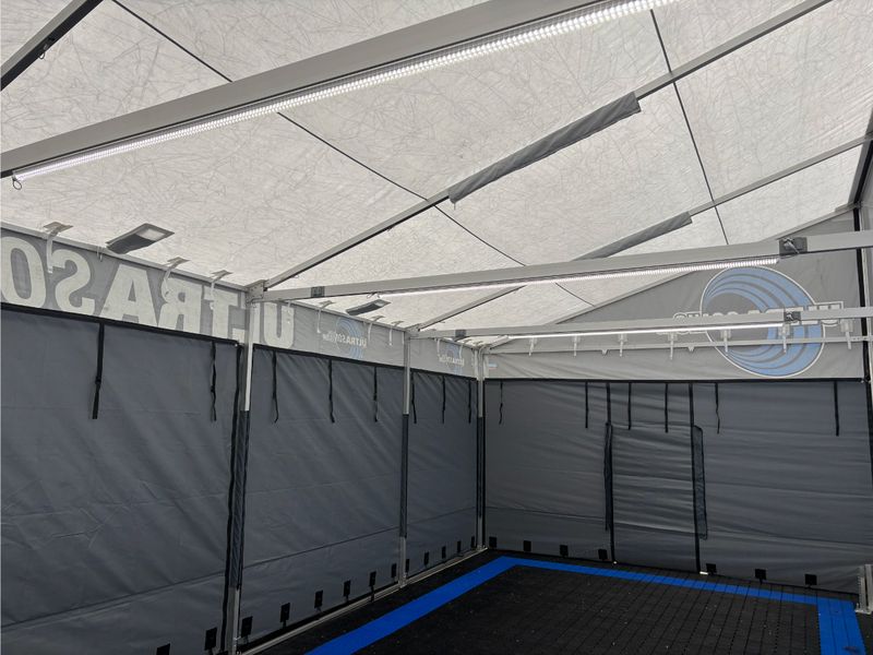 Inside the Phil Esz team enclosure with zip-in sidewalls, blue floor tiles and custom lighting