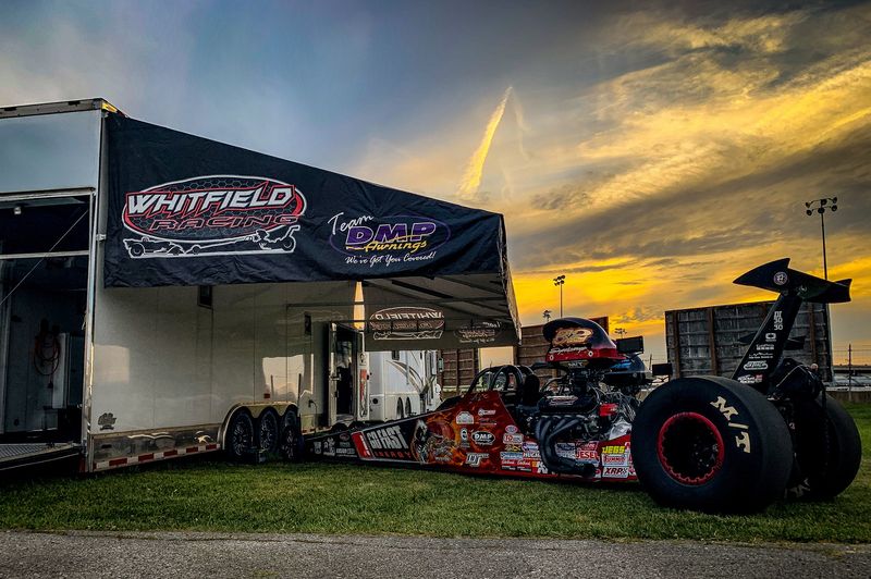 Whitfield Family Racing trailer awning at sunset with their dragster parked alongside